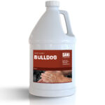 Un bidon en plastique blanc étiqueté BULLDOG, savon pour les mains de SANI, avec une image de mains en train d'être lavées. L'étiquette comporte des informations de contact et un fond rouge.